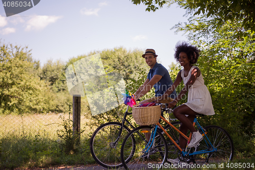 Image of Young multiethnic couple having a bike ride in nature