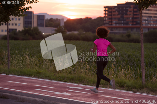 Image of a young African American woman jogging outdoors