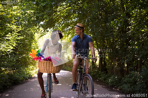 Image of Young multiethnic couple having a bike ride in nature