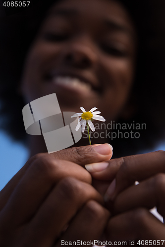 Image of portrait of African American girl with a flower in her hand
