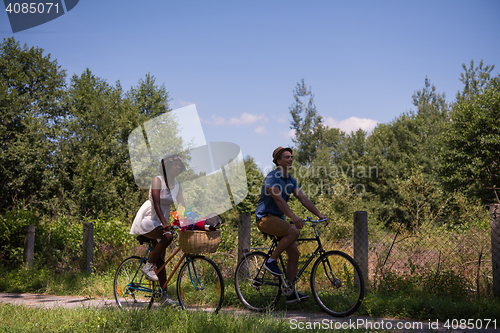 Image of Young multiethnic couple having a bike ride in nature