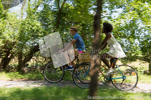Image of Young multiethnic couple having a bike ride in nature
