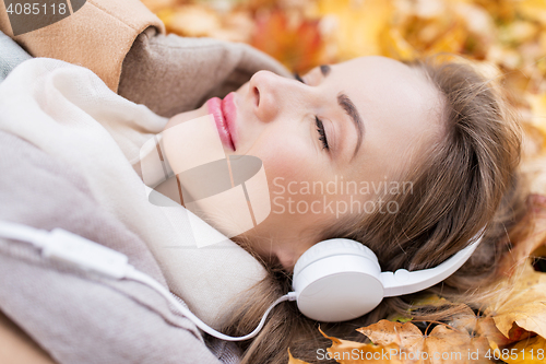Image of woman with headphones listening to music in autumn