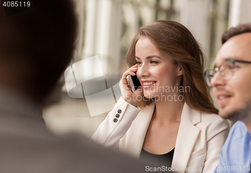 Image of businesswoman calling on smartphone at office