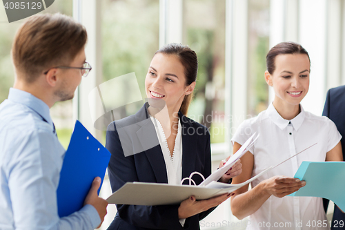 Image of business team with folders meeting at office