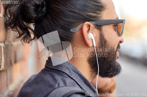 Image of close up of man with earphones listening to music