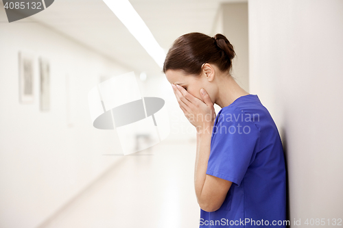 Image of sad or crying female nurse at hospital corridor