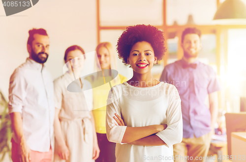 Image of happy young woman over creative team in office