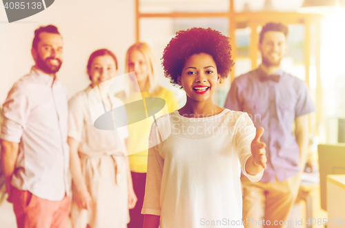 Image of woman making handshake over creative office team