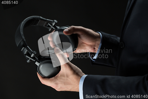 Image of close up of businessman hands holding headphones