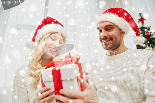 Image of happy couple at home with christmas gift box