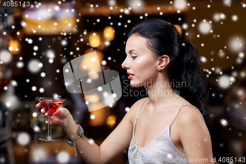 Image of glamorous woman with cocktail at night club or bar