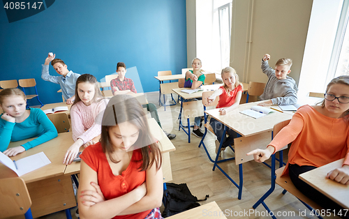 Image of students gossiping behind classmate back at school