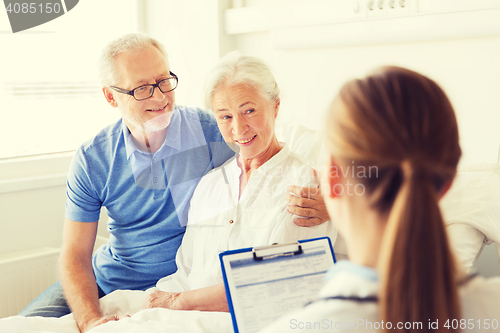 Image of senior woman and doctor with clipboard at hospital