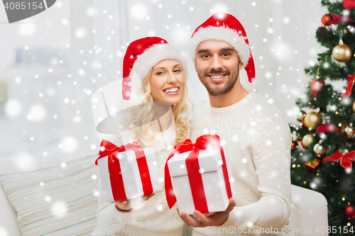 Image of happy couple at home with christmas gift boxes