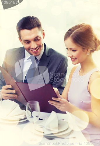 Image of smiling couple with menu at restaurant