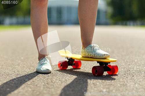 Image of close up of female feet riding short skateboard