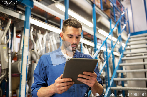 Image of auto mechanic or smith with tablet pc at workshop