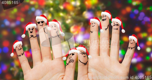 Image of close up of fingers with smiley in santa hats