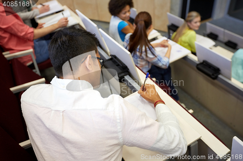 Image of group of students with notebooks in lecture hall