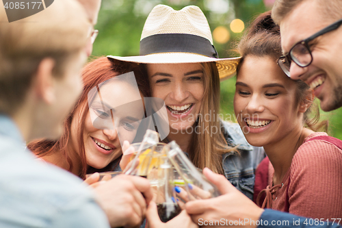 Image of happy friends clinking glasses at summer garden