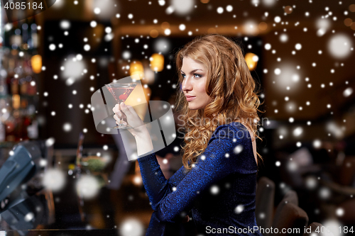 Image of glamorous woman with cocktail at night club or bar