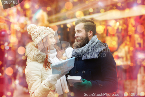 Image of happy couple with map and city guide in old town