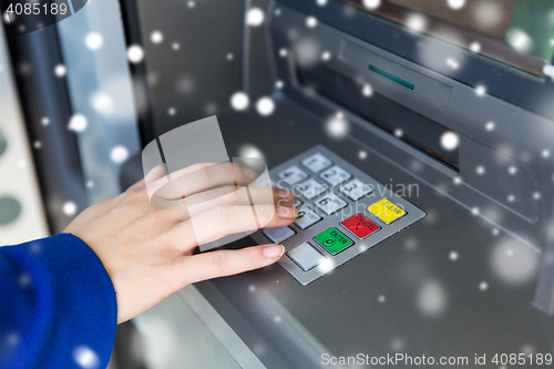 Image of close up of hand entering pin code at cash machine