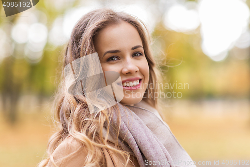 Image of beautiful happy young woman smiling in autumn park
