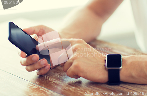 Image of close up of hands with smart phone and watch