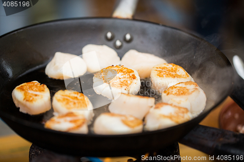 Image of close up of scallops frying in cast iron pan