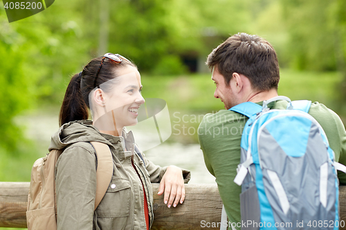 Image of smiling couple with backpacks in nature