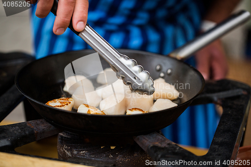 Image of close up of scallops frying in cast iron pan