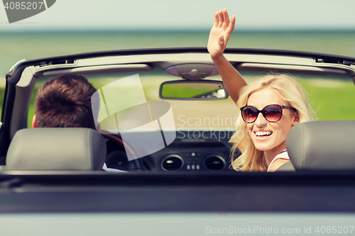 Image of happy man and woman driving in cabriolet car