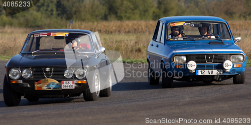 Image of Two vintage cars on a circuit.