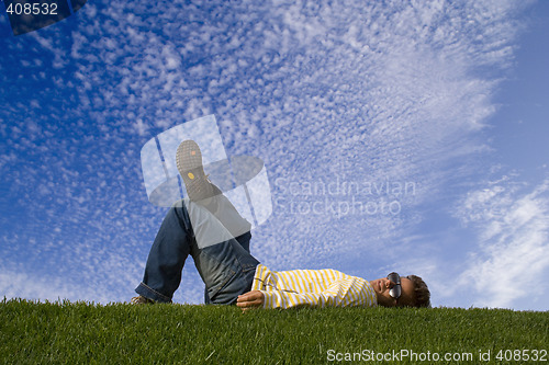 Image of Young man lying down on the grass