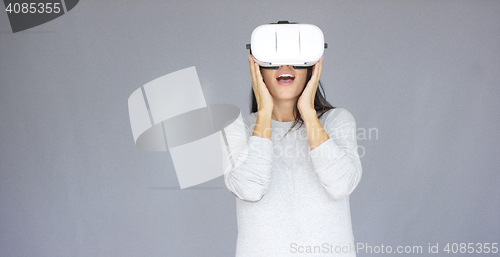 Image of Excited woman watching something on her virtual reality helmet