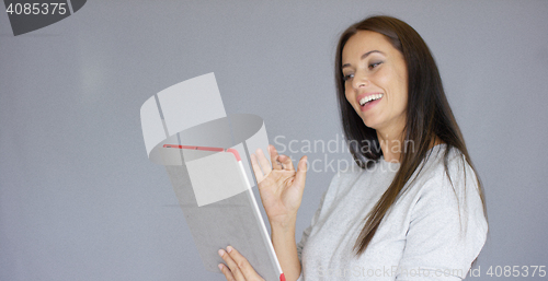 Image of Happy smiling brunette woman video chatting on tablet computer