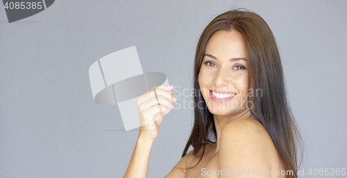 Image of Cute single young adult woman with hand near face