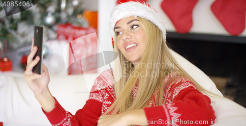 Image of Sexy blond girl in Christmas outfin taking a selfie