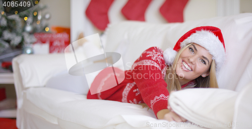 Image of Beautiful girl in Santa Claus hat in her living room