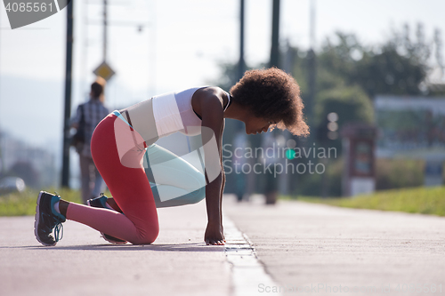 Image of Portrait of sporty young african american woman stretching outdo