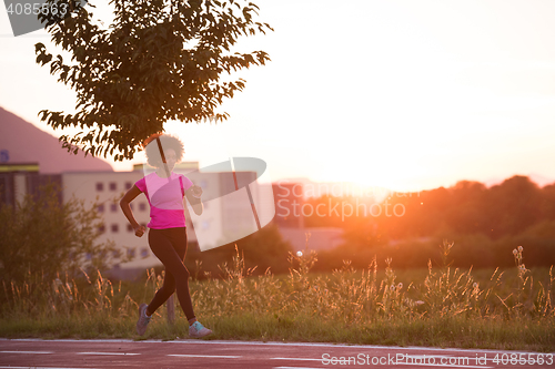 Image of a young African American woman jogging outdoors