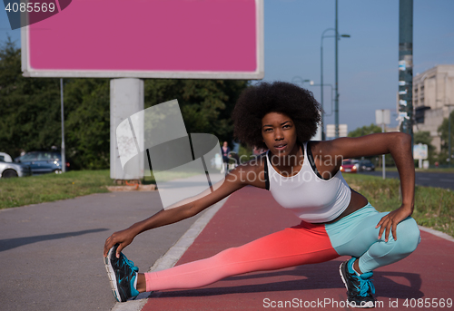 Image of Portrait of sporty young african american woman stretching outdo