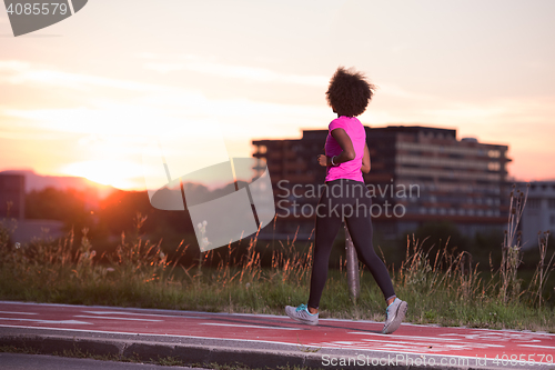 Image of a young African American woman jogging outdoors