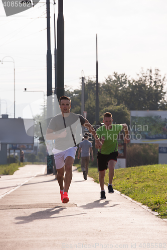 Image of Two young men jogging through the city