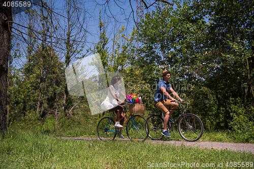 Image of Young multiethnic couple having a bike ride in nature