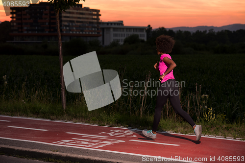 Image of a young African American woman jogging outdoors