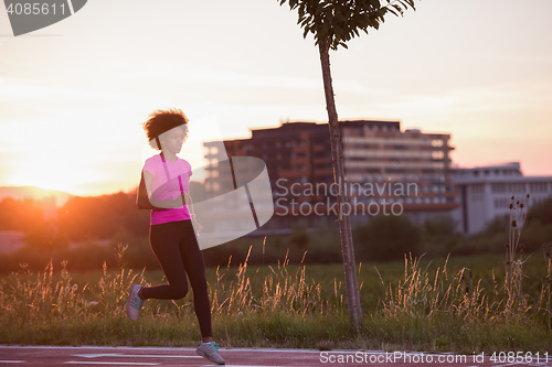 Image of a young African American woman jogging outdoors