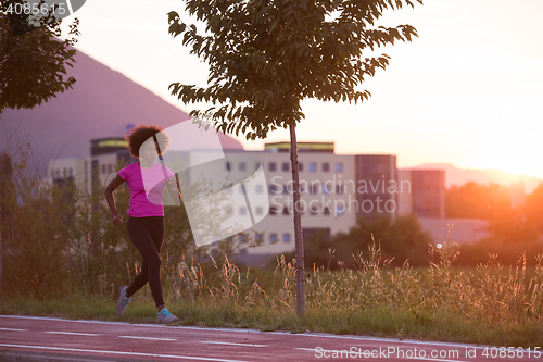 Image of a young African American woman jogging outdoors